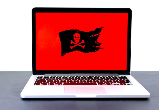 Laptop with a red screen and pirate flag.